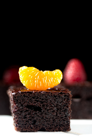 Pieces of Dark chocolate cake decorated with tangerineの写真素材