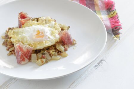 Fried eggs with ham and vegetablesの写真素材