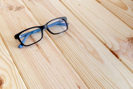 Blue and black glasses on wood table backgroundの写真素材