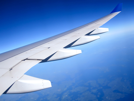Wing of the plane on blue sky background. Traveling concept. Photo applied to tourism operatorsの写真素材