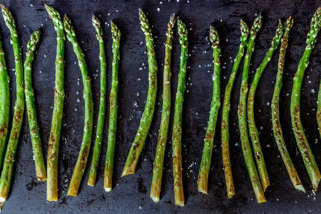 Baked asparagus on a dark background.の写真素材