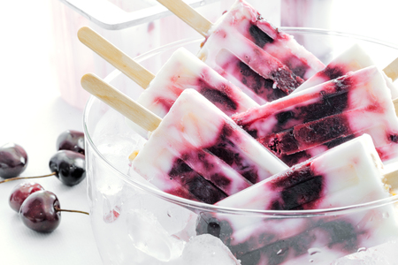Yogurt and cherries popsicles in a bowl. Refreshing summer dessertの写真素材