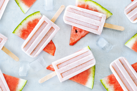 Natural watermelon juice popsicles with ice cubes over gray background. Healthy summer dessert.の写真素材