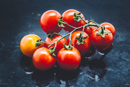 Cherry tomatoes on dark metal background.の写真素材