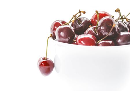 Sweet Cherries in bowl. Closeup of Fresh cherries isolated on white background.の写真素材