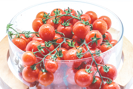 Fresh Cherry tomatoes in glass bowl on white background.の写真素材