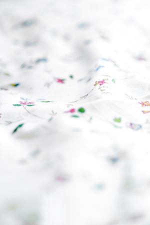 Close up of wrinkled white color fabric and floral bed sheet texture background.の写真素材