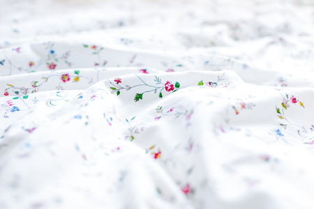 White and floral bed sheets backgroundの写真素材
