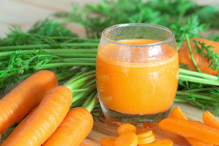 Glass of carrot juice and vegetables on wooden table. Healthy eating, food, dieting and vegetarian concept.の写真素材