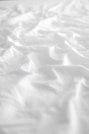 View of the crease of an unmade bed sheet in the bedroom after a night sleep and waking up in the morning.の写真素材