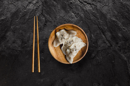 Plate of Japanese gyoza dumplings on black slate stone.の写真素材