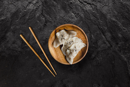Plate of Asian gyoza dumplings on black slate stone.の写真素材