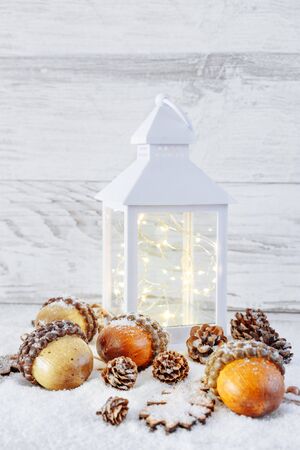 Christmas Lantern with decorations on wooden background with snowの写真素材