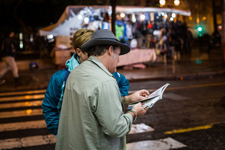 Seville, Spain - January 13, 2018: Man helping to a tourist to find a location in a paper map on the street. The city of Seville is famous worldwide for its culture, monuments, traditions and artistic heritage. This is the birthplace of Flamenco and the cのeditorial素材