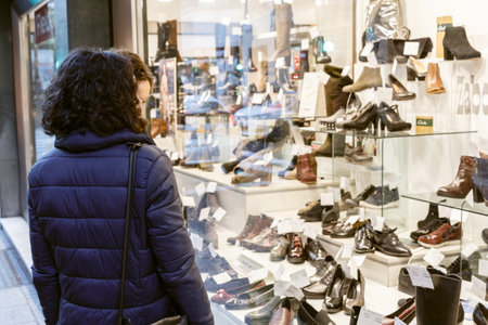 Seville, Spain - January 13, 2018: Women shopping. Women in the sales looking at shoe store. Twice a year in Spain shoppers are treated to an end-of-season sale period, called las rebajas, in which goods can be purchased at a significant discount.のeditorial素材