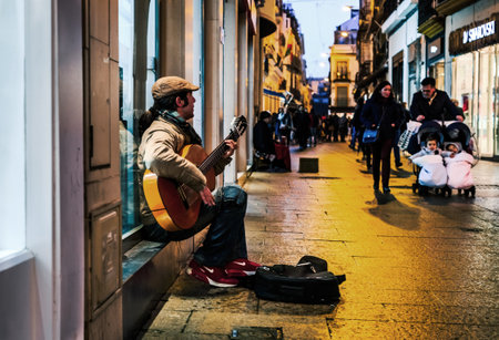 Seville, Spain - January 13, 2018: Flamenco guitarist in the streets of sevilla at night. Flamenco is a professionalized art-form based on the various folkloric music traditions of Southern Spain in the autonomous communities of Andalusia, Extremadura andのeditorial素材