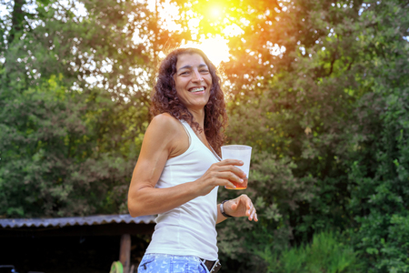 Beautiful young woman holding soda and smiling at summer. Summer joy concept.の写真素材