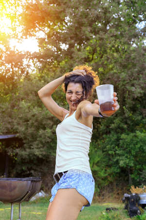 Happy young woman dancing and having fun at summer party at sunset. Summer joy concept.の写真素材