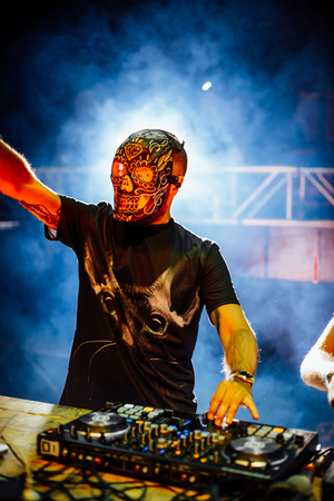 DJ with Skull mask playing electronic music at Summer Party Festival. Fun, youth, entertainment and fest concept.の写真素材