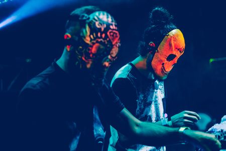 Amazing Djs with mask playing mixing music at Summer Party Festival. Fun, youth, entertainment and fest concept.の写真素材
