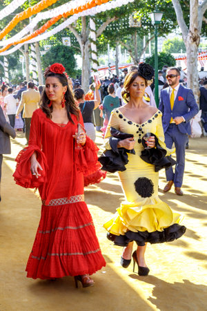 Seville, Spain - May 03, 2017:  Attractive Women taking a walk and dressed in traditional costumes at the Seville's April Fair.のeditorial素材