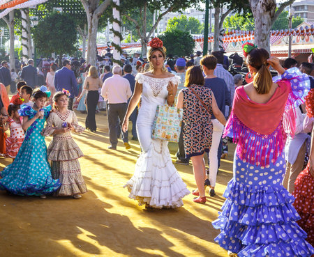 Seville, Spain - May 03, 2017:  Attractive Women taking a walk and dressed in traditional costumes at the Seville's April Fair.のeditorial素材