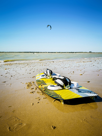 Kitesurf Board in the sand at the beach against ocean and beautiful blue sky. Holidays on nature. Water sports, hobbies and fun in summer.の写真素材