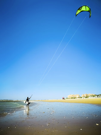 Cadiz, Spain - May 12, 2018:  Kite surfer on the ocean beach.  Kiteboarding is an action sport combining aspects of wakeboarding, snowboarding, windsurfing, surfing, paragliding, skateboarding and sailing into one extreme sportのeditorial素材