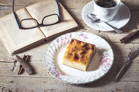 Sweet homemade apple cake and coffee. Breakfast and reading on rustic wooden table.
の写真素材
