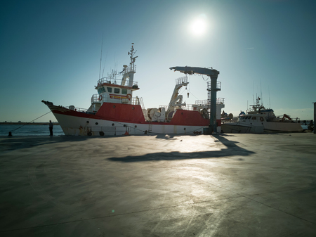 Fishing boat in a Spanish harbor. Front view backlight maritime scene.の写真素材