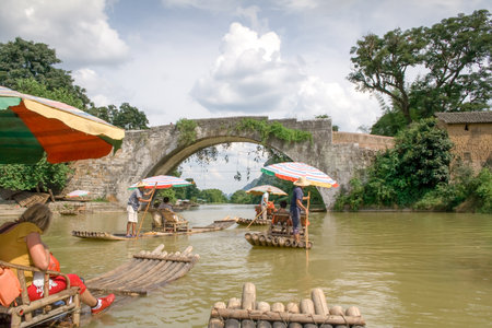 Yangshuo, China - July 14, 2010: Traditional bamboo raft on Yulong River, Yangshuo, Guangxi, China. The most popular way to enjoy the scenery of the Yulong River is to take a bamboo raft.のeditorial素材