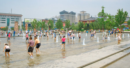 Xian, China - July 25, 2010: Local people and tourists playing with the water during summer in the Music Fountain, Dayan Pagoda Square, Xian, China. For most tourists, the square is famous for its big music fountain, which is said to be the largest music のeditorial素材