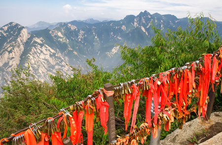 Gold padlocks and red ribbons on the sacred Huashan mountain.の写真素材