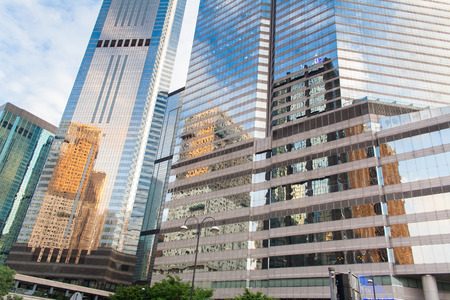 Modern office buildings in central Hong Kong. Modern architecture with windows reflecting sky and clouds.の写真素材