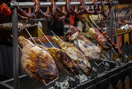 Row of roasted pork legs and sausages on the street market in Spainの写真素材