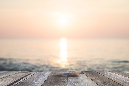 Wooden free space on table with beautiful sunset beach over the seaの写真素材