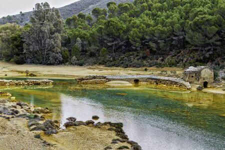 Old water mill on the colorful river Odiel with pine forest in Huelva, Andalucia, Spainの写真素材