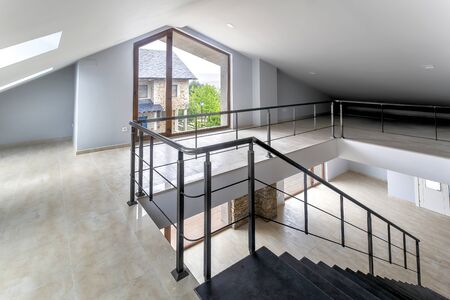 Indoor view of an empty attic with large windows of a new modern house.の写真素材