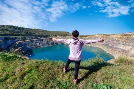 Woman traveling alone enjoying open pit mining landscape. Adventure trip lifestyle vacations...