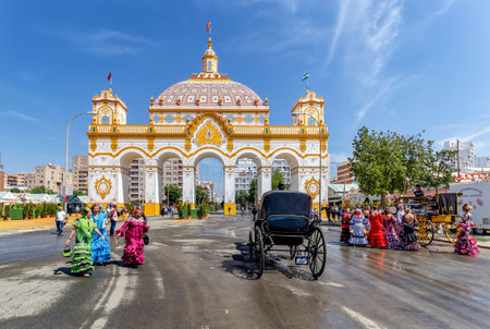Seville, Spain - May 07, 2019 :Entrance arch (Portada) and women wearing traditional flamenco dress at the April Fair ((Feria de Abril), Seville Fair (Feria de Sevilla), Andalusia, Spainのeditorial素材