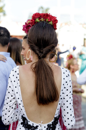 Seville, Spain - May 09, 2019 : Beautiful woman wearing flamenco dress. Detail of Traditional Spanish Hairstyle. Spanish folklore. April Fair (Feria de Abril), Seville Fair (Feria de Sevilla), Andalusia, Spainのeditorial素材