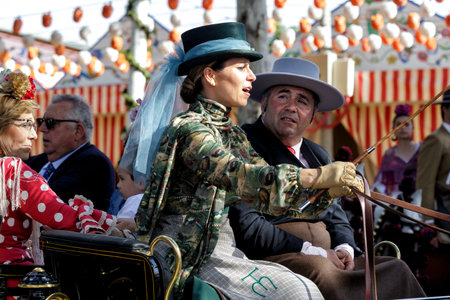 Seville, Spain - May 09, 2019 : Elegant woman driving horse carriage at the April Fair (Feria de Abril), Seville Fair (Feria de Sevilla), Andalusia, Spainのeditorial素材