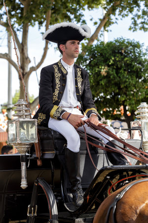 Seville, Spain - May 09, 2019 : Elegant driver horse carruage in traditional clothing at the April Fair (Feria de Abril), Seville Fair (Feria de Sevilla), Andalusia, Spainのeditorial素材