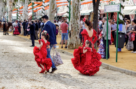 Seville, Spain - May 09, 2019 : Family wearing traditional flamenco dress enjoying at the April Fair (Feria de Abril), Seville Fair (Feria de Sevilla), Andalusia, Spainのeditorial素材