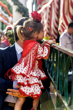 Seville, Spain - May 09, 2019 : Nice and tender scene of father and daughter in traditional dress at the April Fair (Feria de Abril), Seville Fair (Feria de Sevilla), Andalusia, Spainのeditorial素材