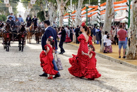 Seville, Spain - May 09, 2019 : Family wearing traditional flamenco dress enjoying at the April Fair (Feria de Abril), Seville Fair (Feria de Sevilla), Andalusia, Spainのeditorial素材