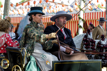Seville, Spain - May 09, 2019 : Elegant woman driving horse carriage at the April Fair (Feria de Abril), Seville Fair (Feria de Sevilla), Andalusia, Spainのeditorial素材