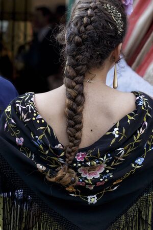 Beautiful woman wearing flamenco dress. Detail of Traditional Spanish Hairstyleat the April Fair (Feria de Abril), Seville Fair (Feria de Sevilla), Andalusia, Spain. Spanish folkloreの写真素材