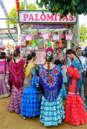 Seville, Spain - May 09, 2019 : Seville, Spain - May 09, 2019 : Girls wearing traditional flamenco dress and shopping sweets at the April Fair (Feria de Abril), Seville Fair (Feria de Sevilla), Andalusia, Spainのeditorial素材
