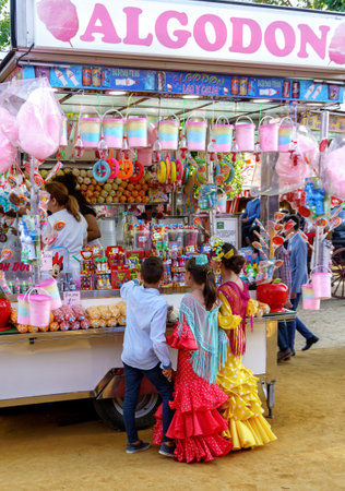 Seville, Spain - May 09, 2019 : Children shopping sweets at the April Fair (Feria de Abril), Seville Fair (Feria de Sevilla), Andalusia, Spainのeditorial素材
